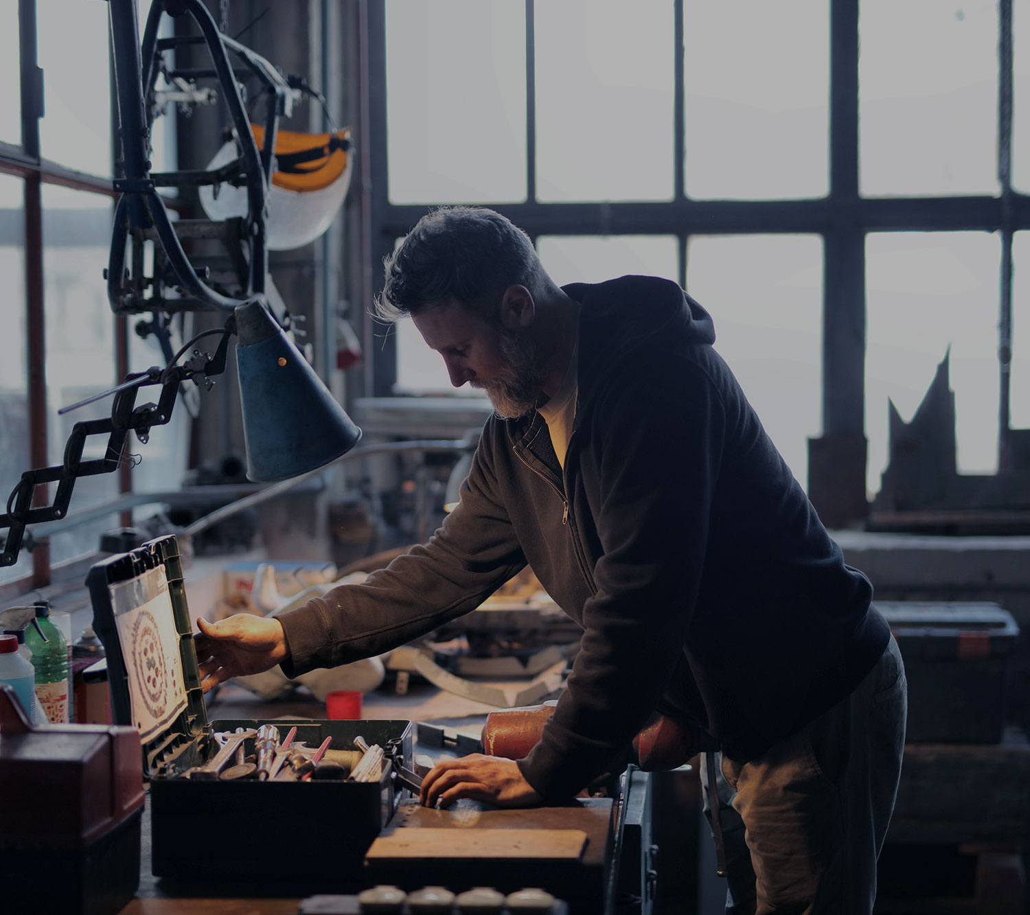 mechanic in workshop with desk light and tool box