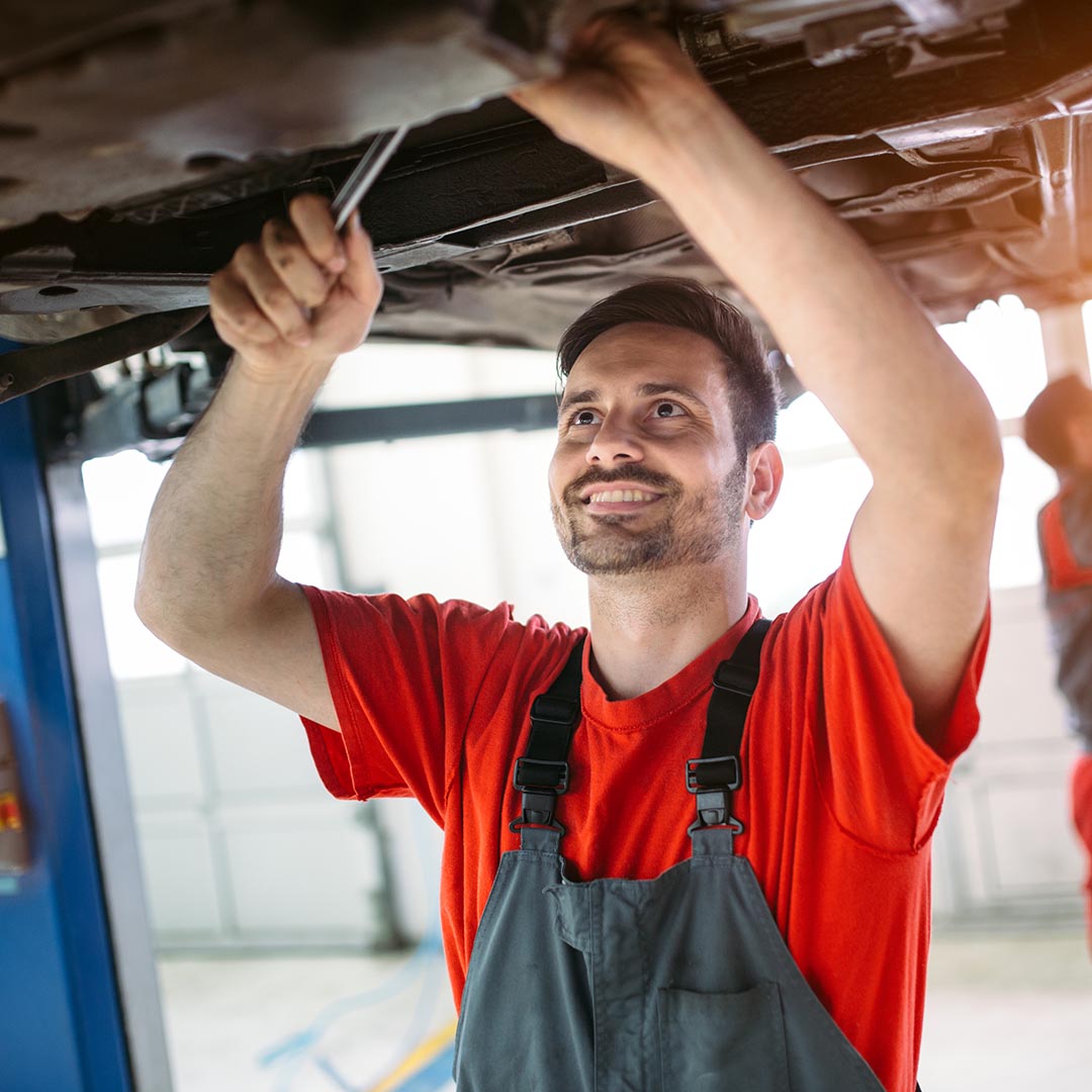 Smiling mechanic working on a car